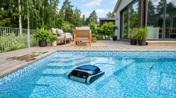 Poolrobot som rengör botten i en kaklad pool intill ett trädäck.